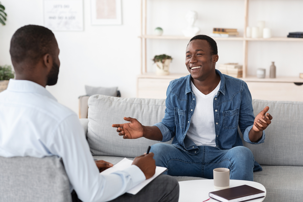 Man talking to a therapist in a therapy office with nice decor